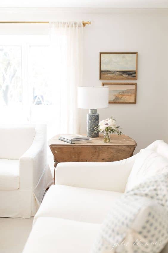 白色的客厅里有两张白色沙发和一张木制茶几。