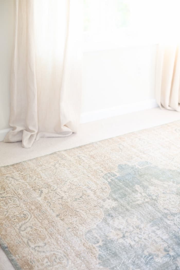 一间卧室里，一条古老的土耳其地毯叠放在旧地毯上。