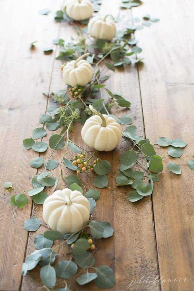 木桌上的南瓜和绿色植物的感恩节核心。