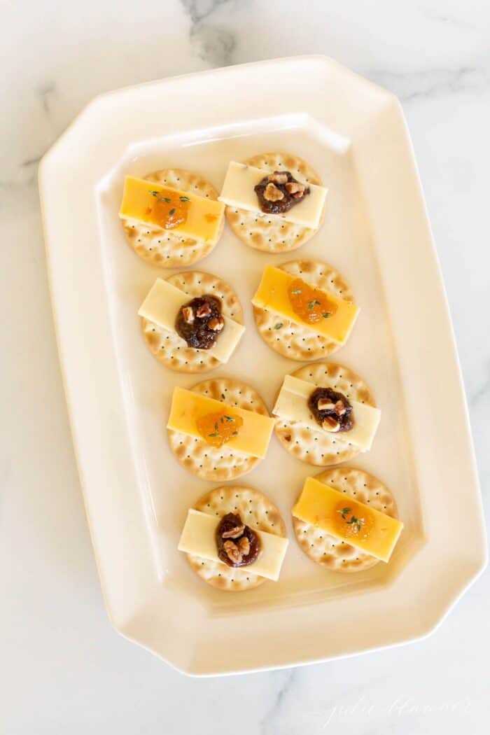 在白色拼盘上的果酱展示各个奶酪和饼干。GydF4y2Ba