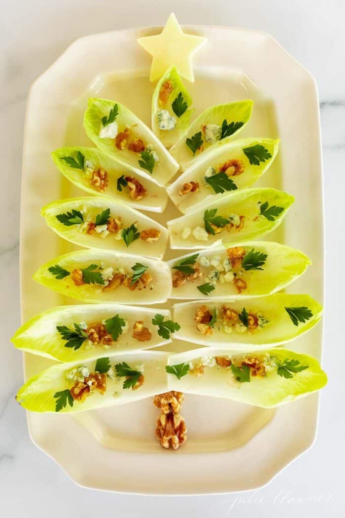 菊苣生菜沙拉放在白色浅盘上，做成圣诞树的形状，作为节日的开胃菜。gydF4y2Ba