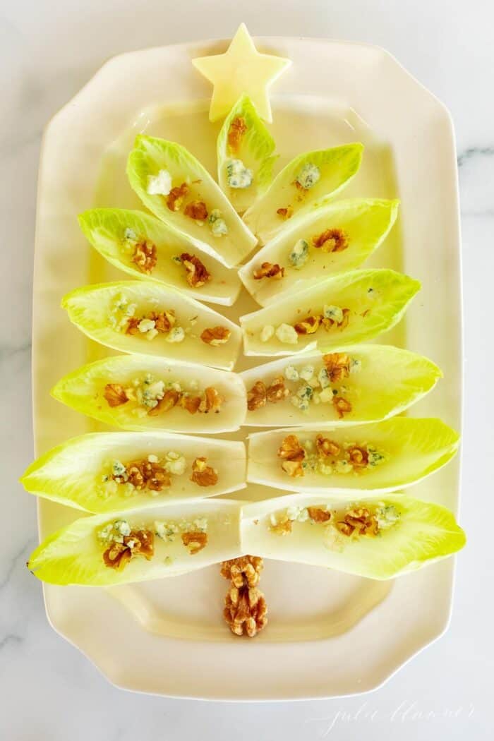 把菊苣叶放在白色浅盘上，做成圣诞树的形状，作为节日的开胃菜。gydF4y2Ba