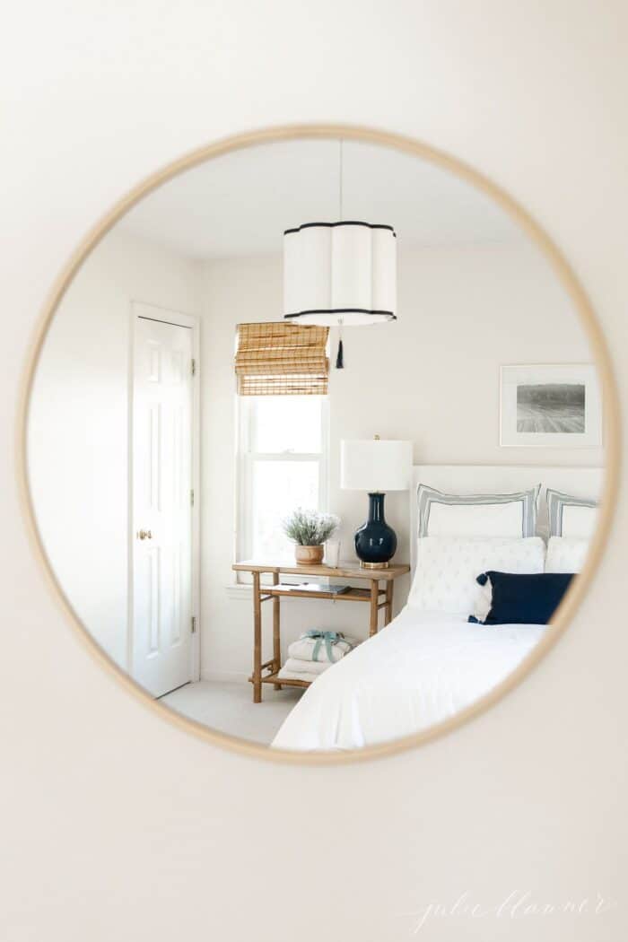 一间白色的客房，通过黄铜镜子的反射呈现出蓝色的色调。