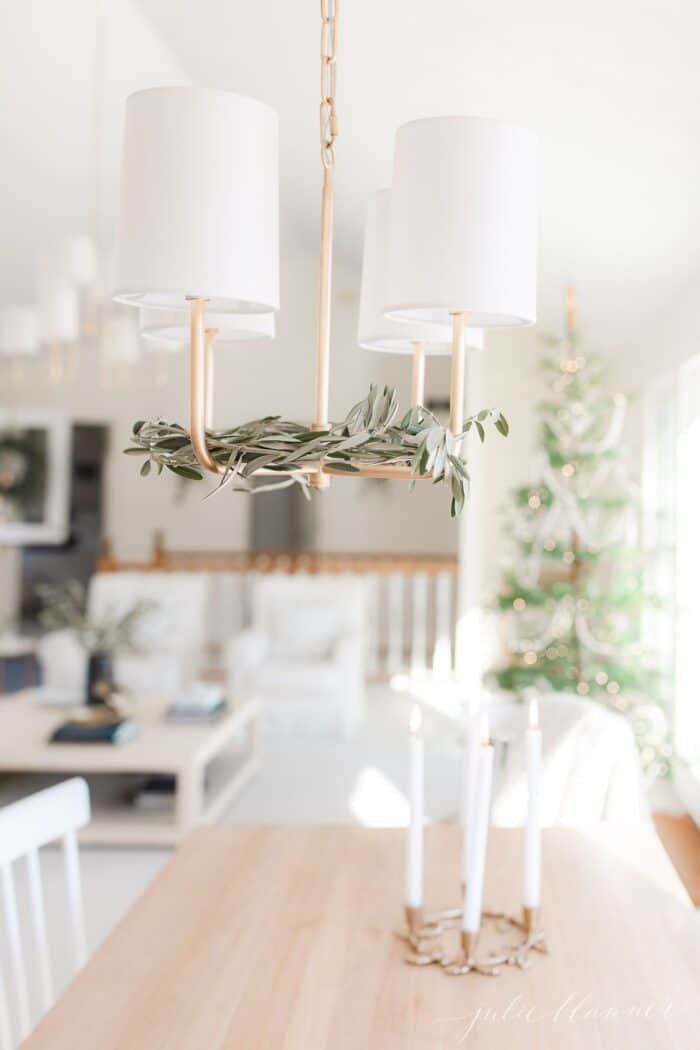 斯堪的纳维亚式圣诞节装饰的客厅里，黄铜枝形吊灯里插着新鲜的橄榄枝。