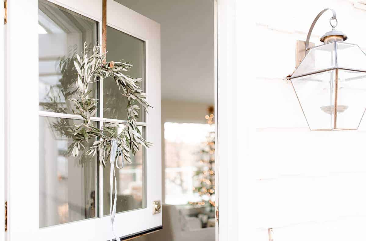 荷兰门开着，带着橄榄树的花环，窥视着家里的斯堪的纳维亚圣诞树
