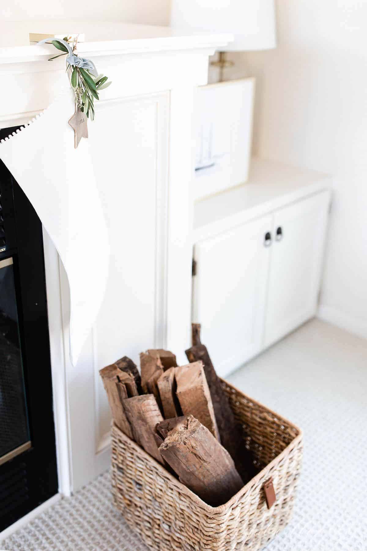 白色的亚麻长袜挂在壁炉上，前面放着一个装满木头的篮子。