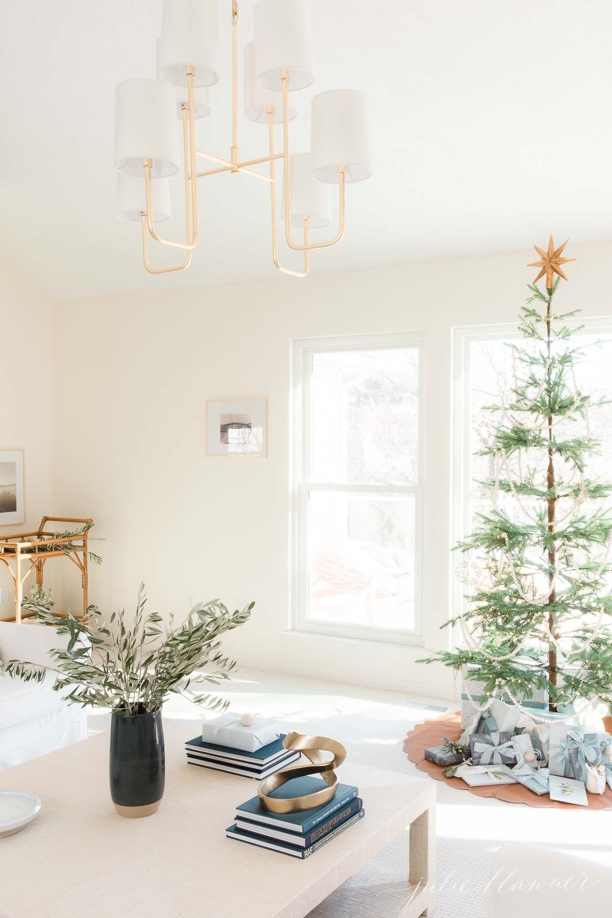一间白色的客厅，装饰得像斯堪的纳维亚的圣诞节，有一棵简单的斯堪的纳维亚树。