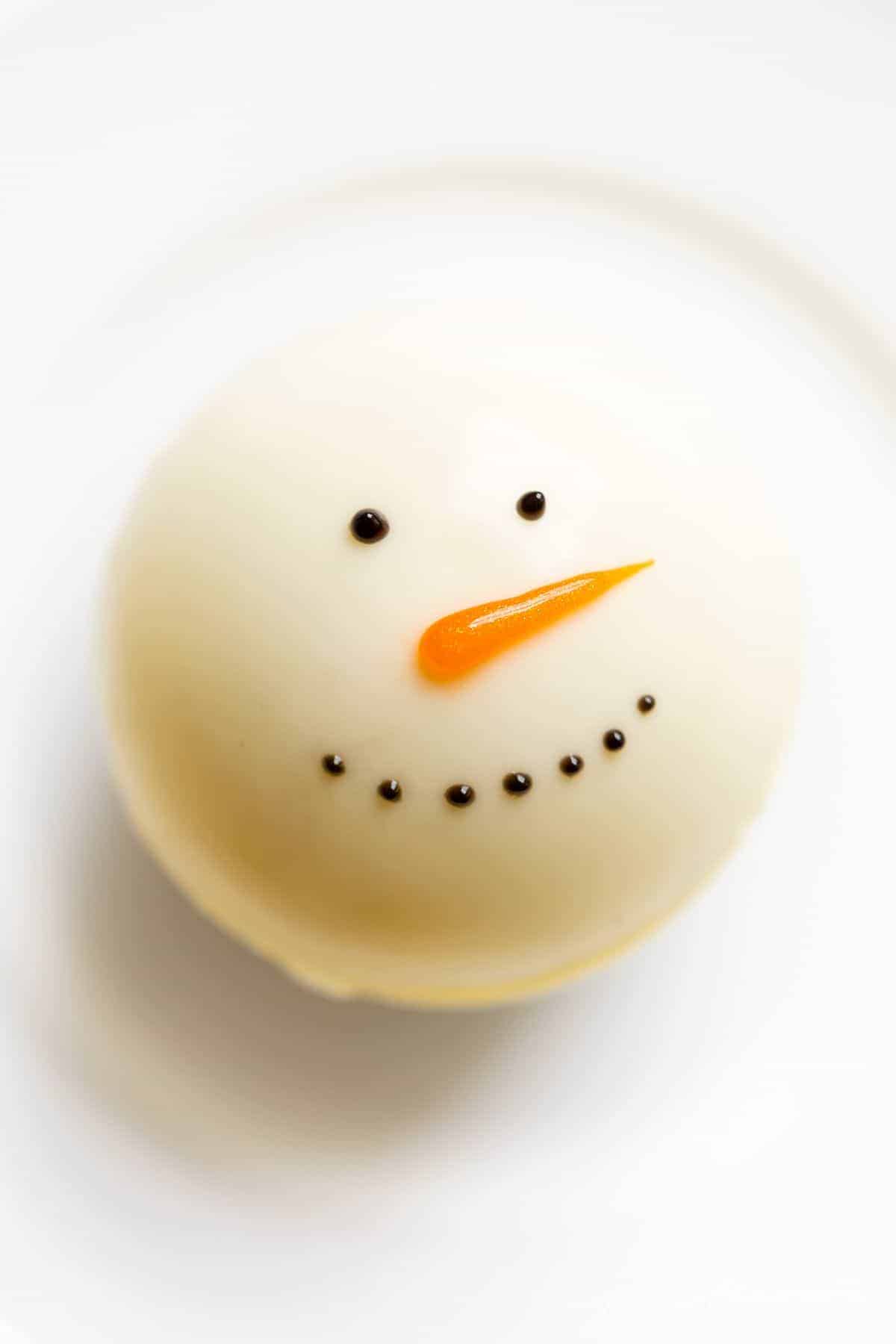 一个雪人热巧克力炸弹在一个白色的盘子。
