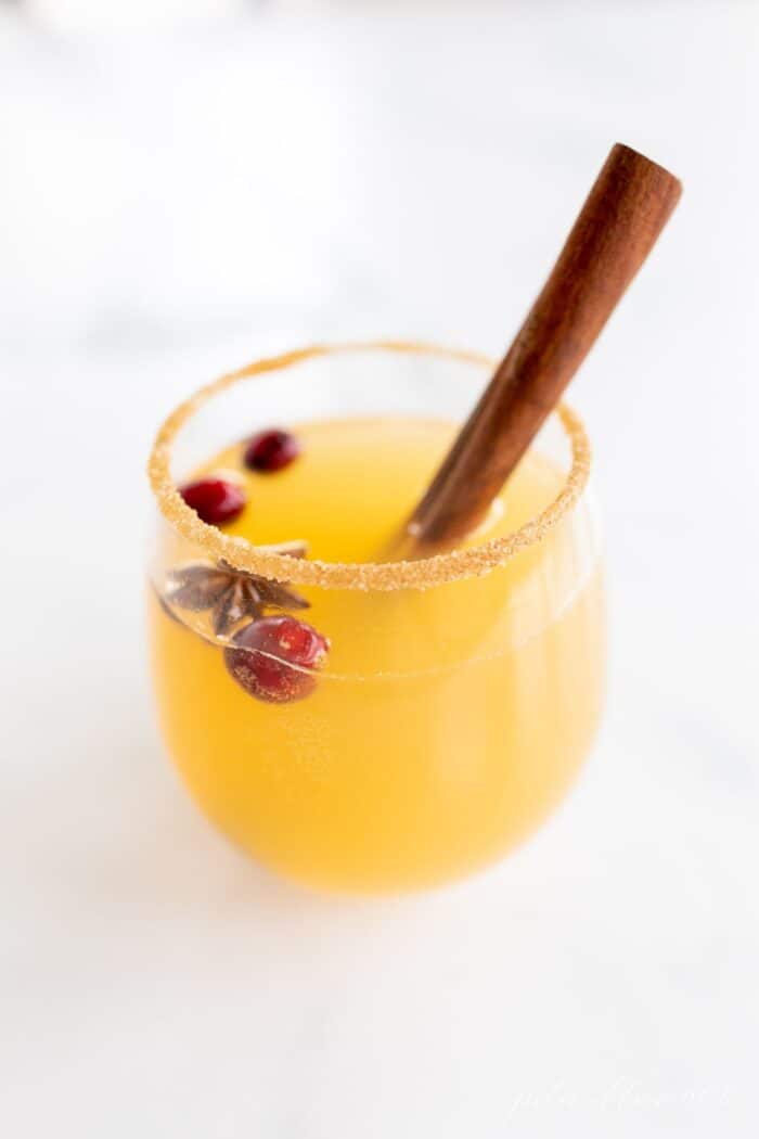 一杯清澈的感恩节桑格利亚汽酒加蔓越莓和肉桂棒。