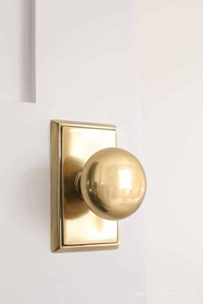 一扇白色的木门，有一个经典的古董黄铜门把手。