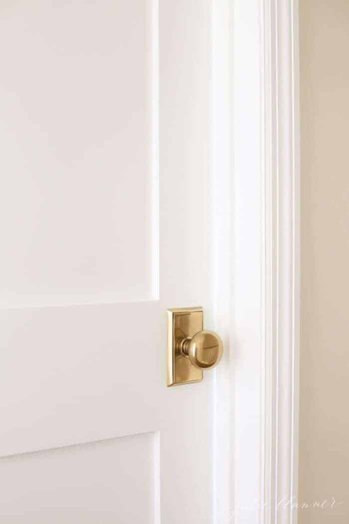 白色木门，带有经典的黄铜门把手。