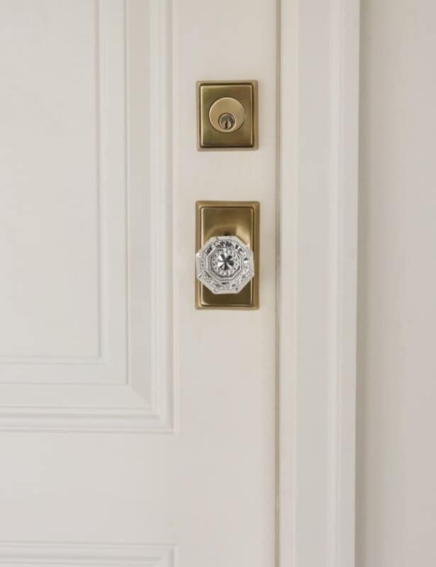 白色木门，带有经典的黄铜和水晶门旋钮。