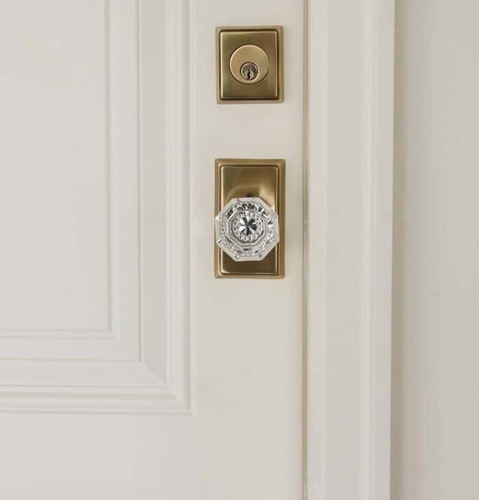 白色木门，带有经典的黄铜和水晶门旋钮。