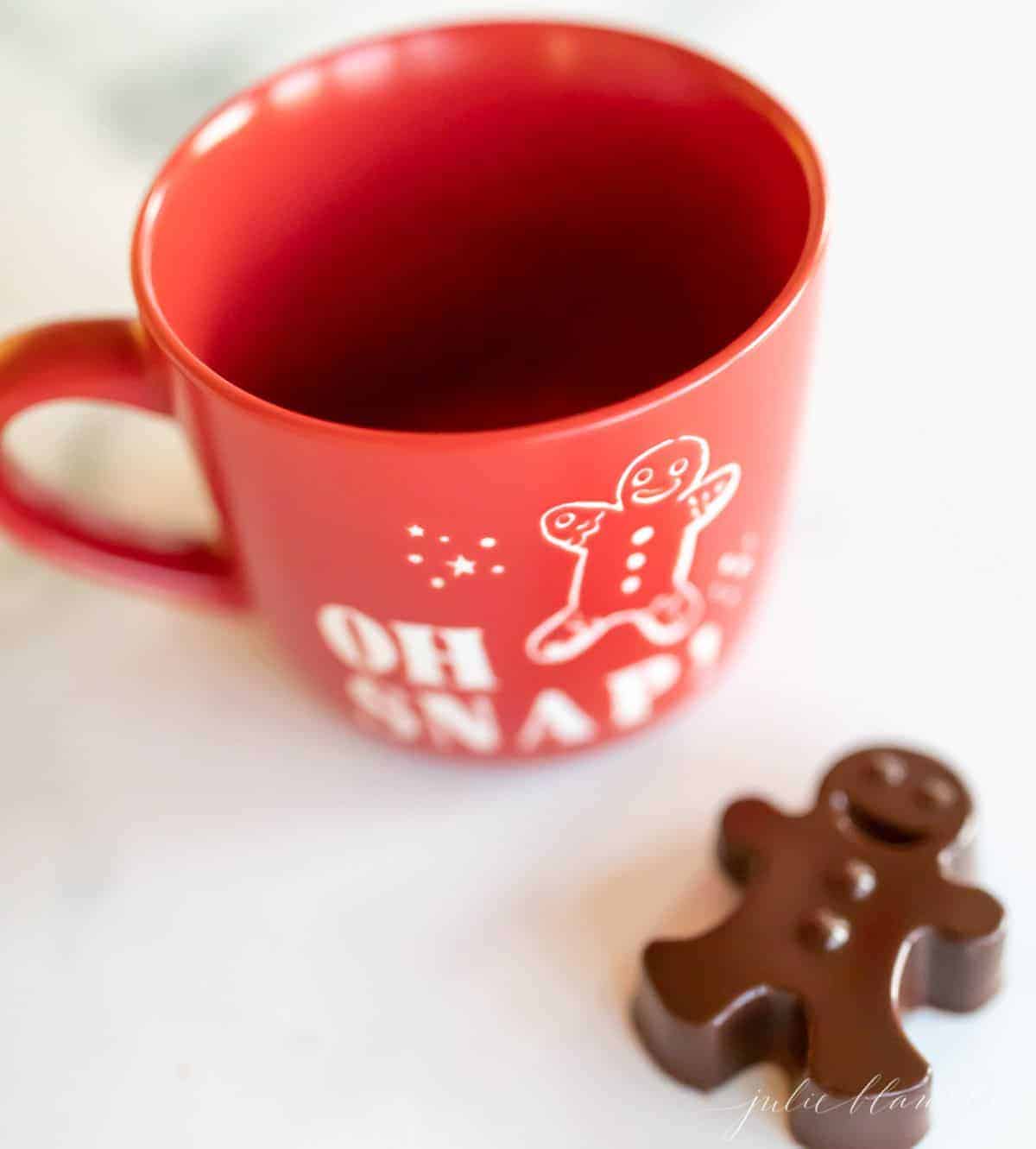 红杯子的热巧克力，用深色的热巧克力炸弹形状像姜饼人一样。GydF4y2Ba