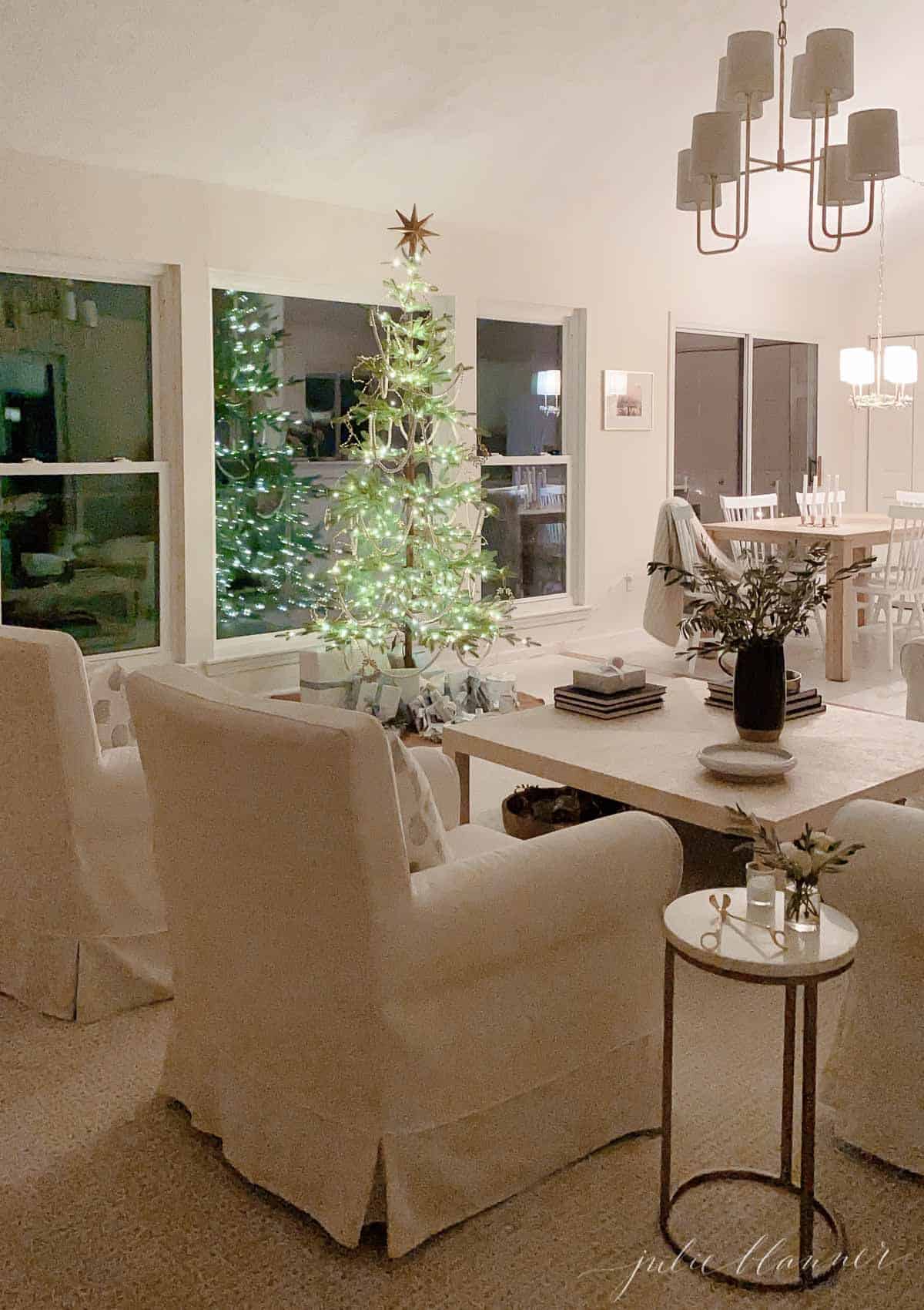 一间白色的客厅，有一棵装饰稀疏的斯堪的纳维亚圣诞树。