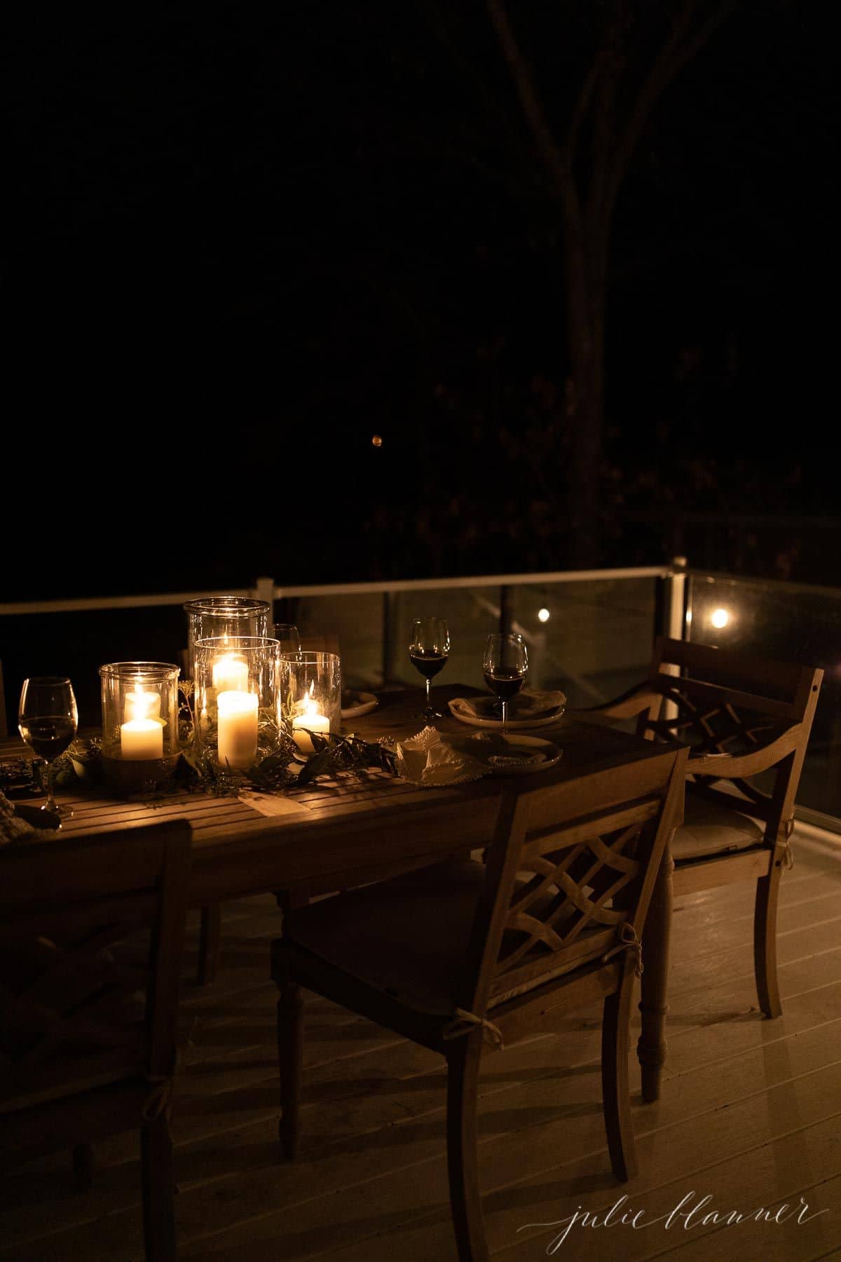 圣诞的户外餐桌，餐桌中央装饰着发光的蜡烛。