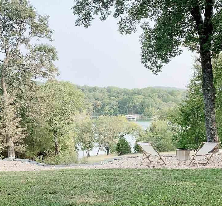 湖景透过树木，周围有一个独奏炉和木制吊带椅。