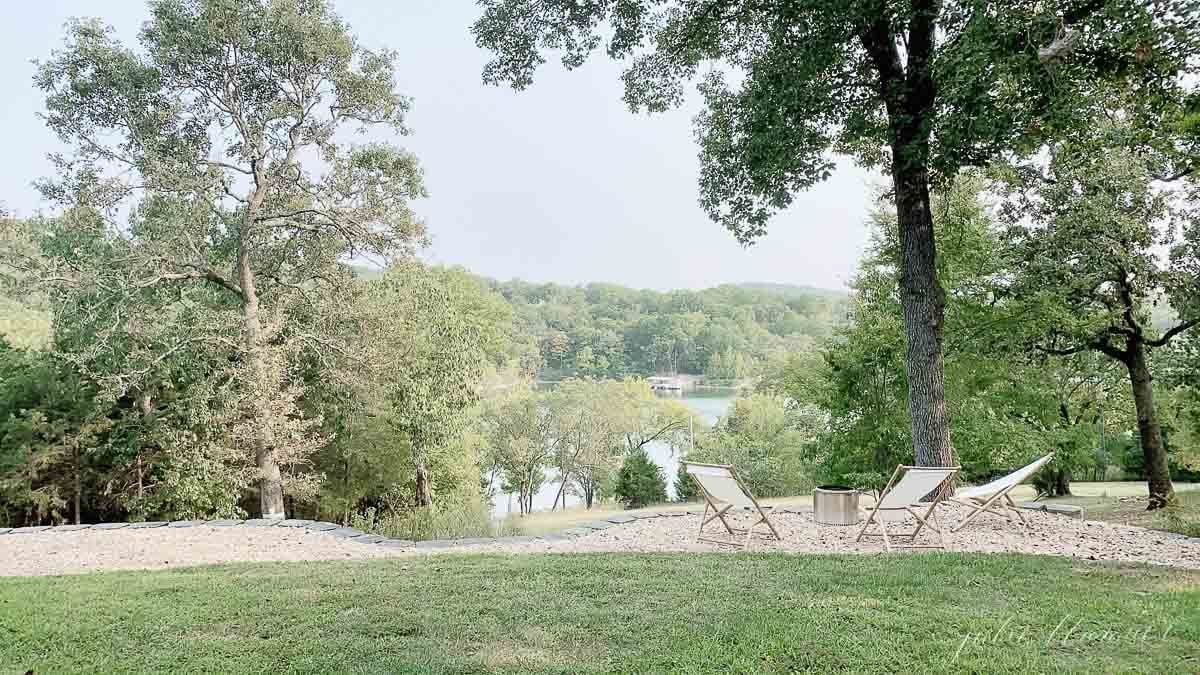 透过树木可以看到湖景，周围有一个单独的火炉和木制吊椅。