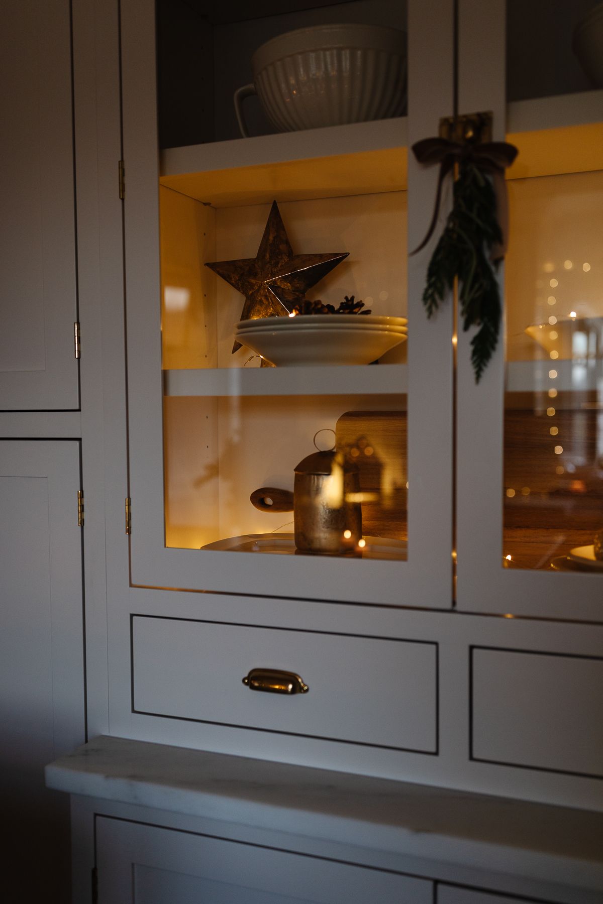厨房里的一个橱柜，里面有传统的圣诞装饰品和彩灯。
