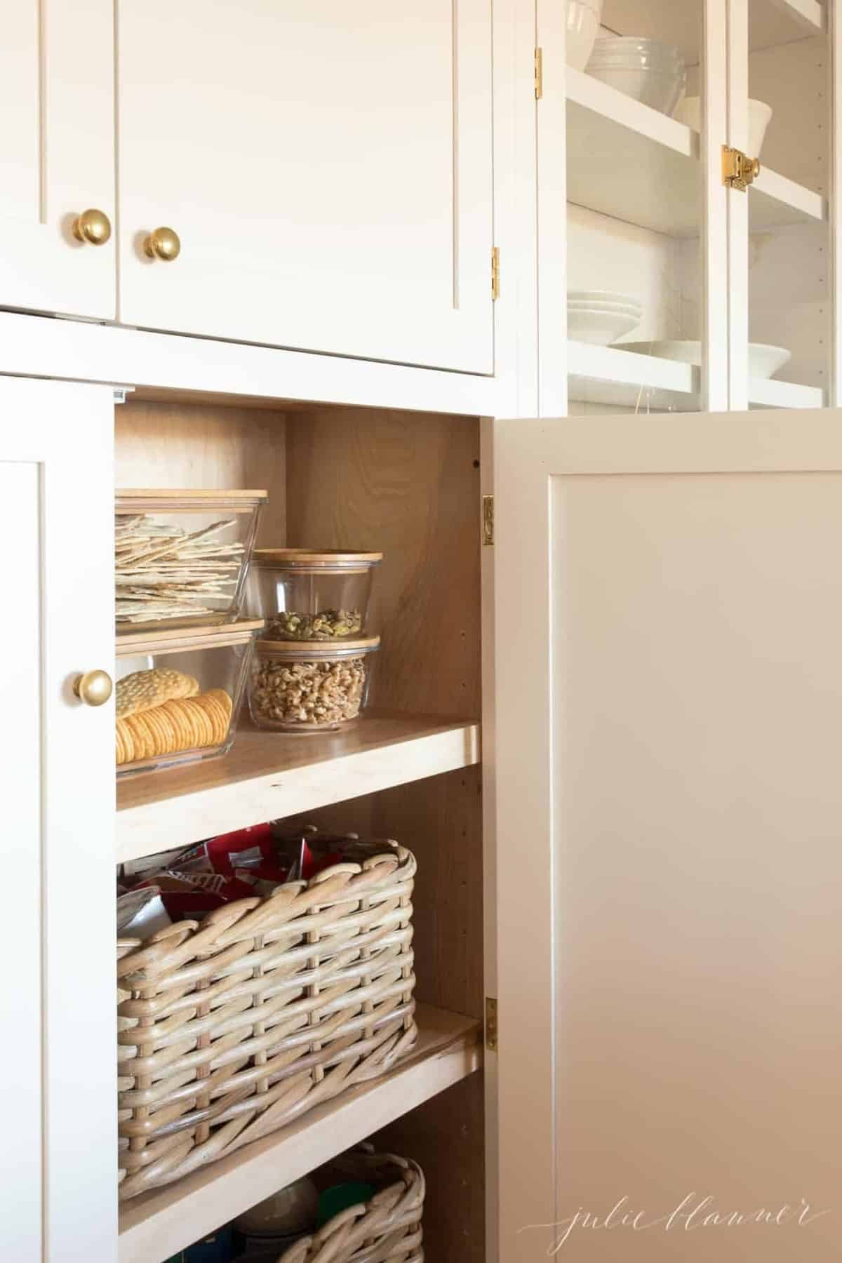 奶油色的厨房橱柜，黄铜的橱柜门把手。