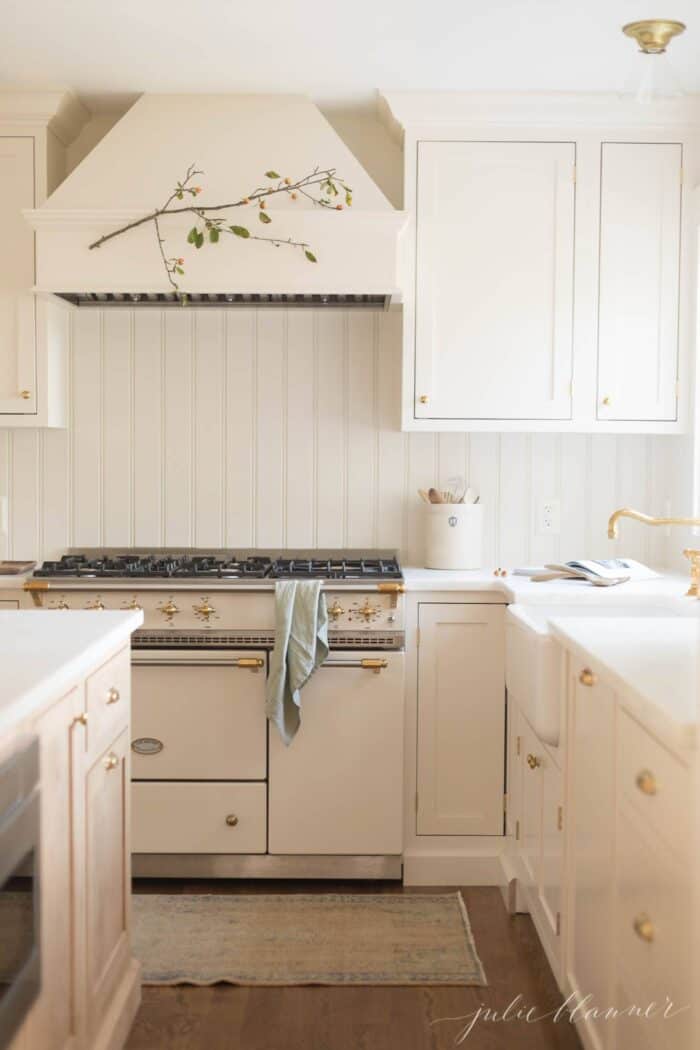 奶油色的经典厨房，配有法式炉灶和嵌入式橱柜。
