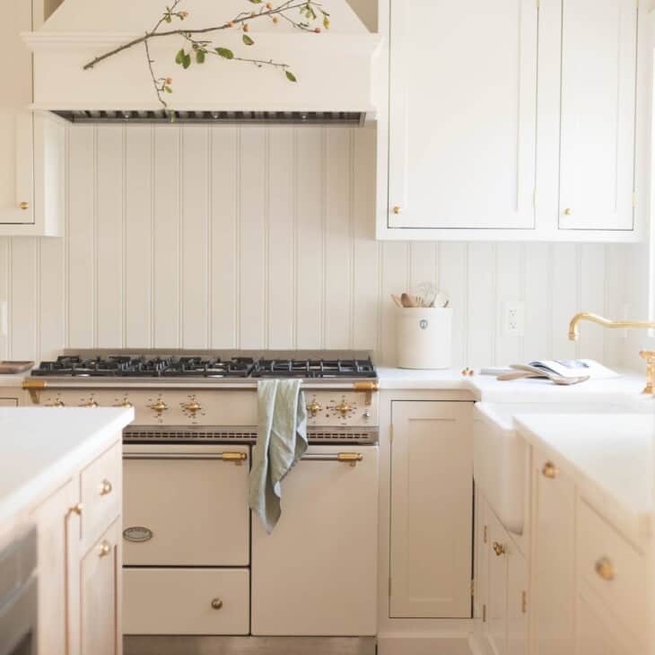 奶油色的经典厨房，配有法式炉灶和嵌入式橱柜。