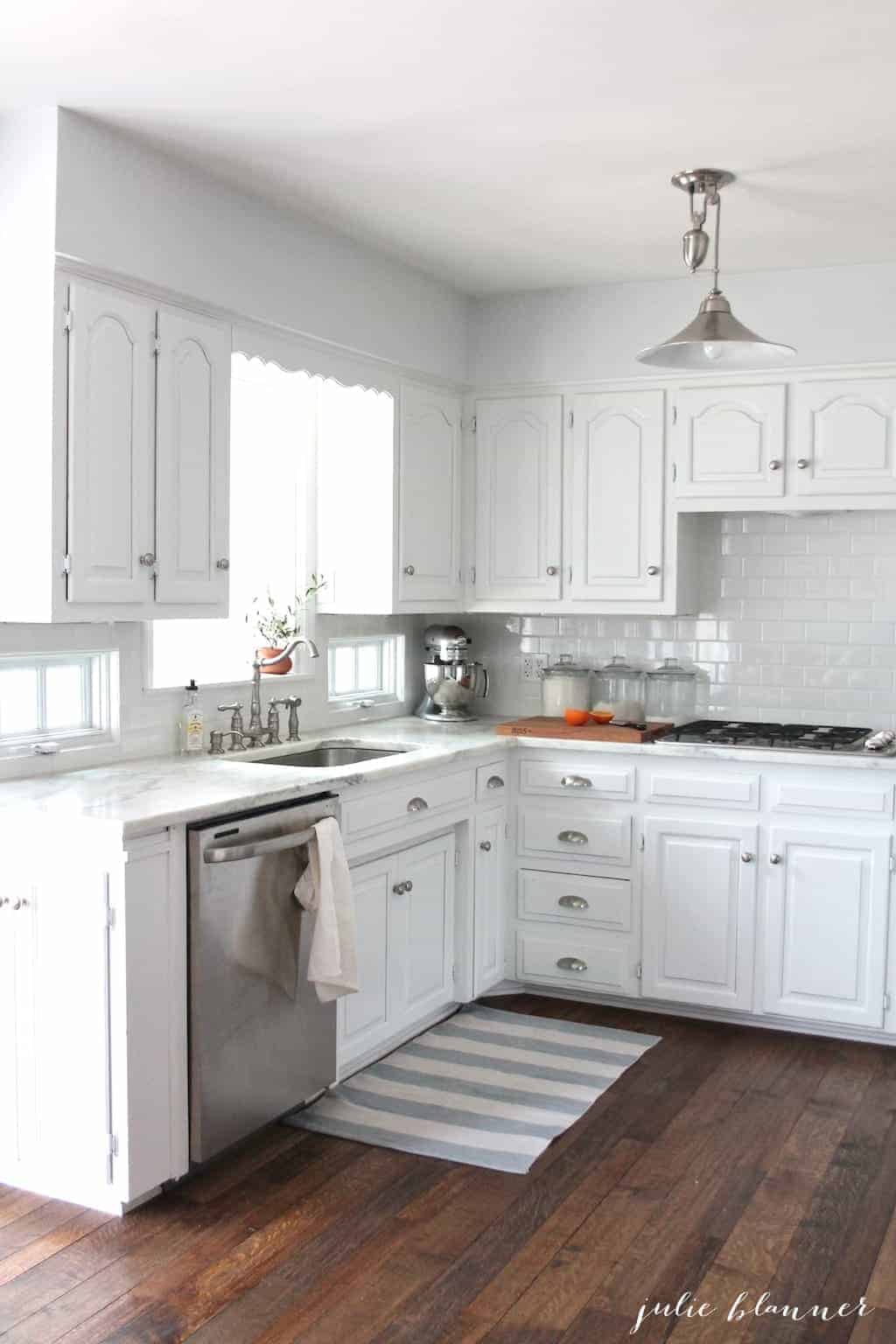 白色厨房，后挡板是白色的地铁瓷砖。