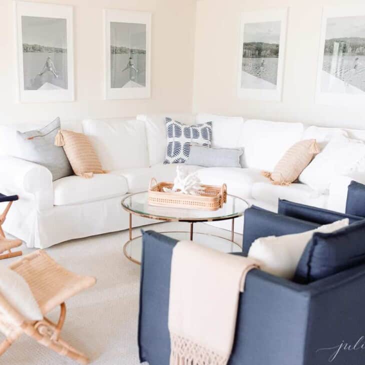 现代的白色客厅，墙壁上有大型黑白照片，白色的沙发和海军蓝色椅子。