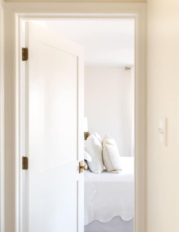 白色的振动器室内门，带有黄铜门把手，打开卧室。