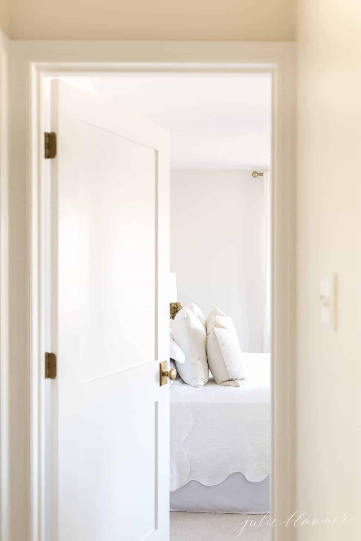 一扇白色的震动派室内门，带有黄铜门把手，通往卧室。
