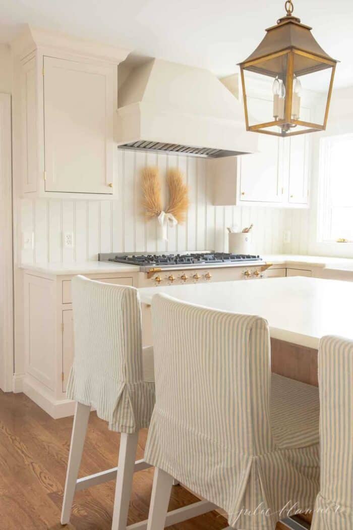 一间白色和木质的厨房，配有大理石软边台面