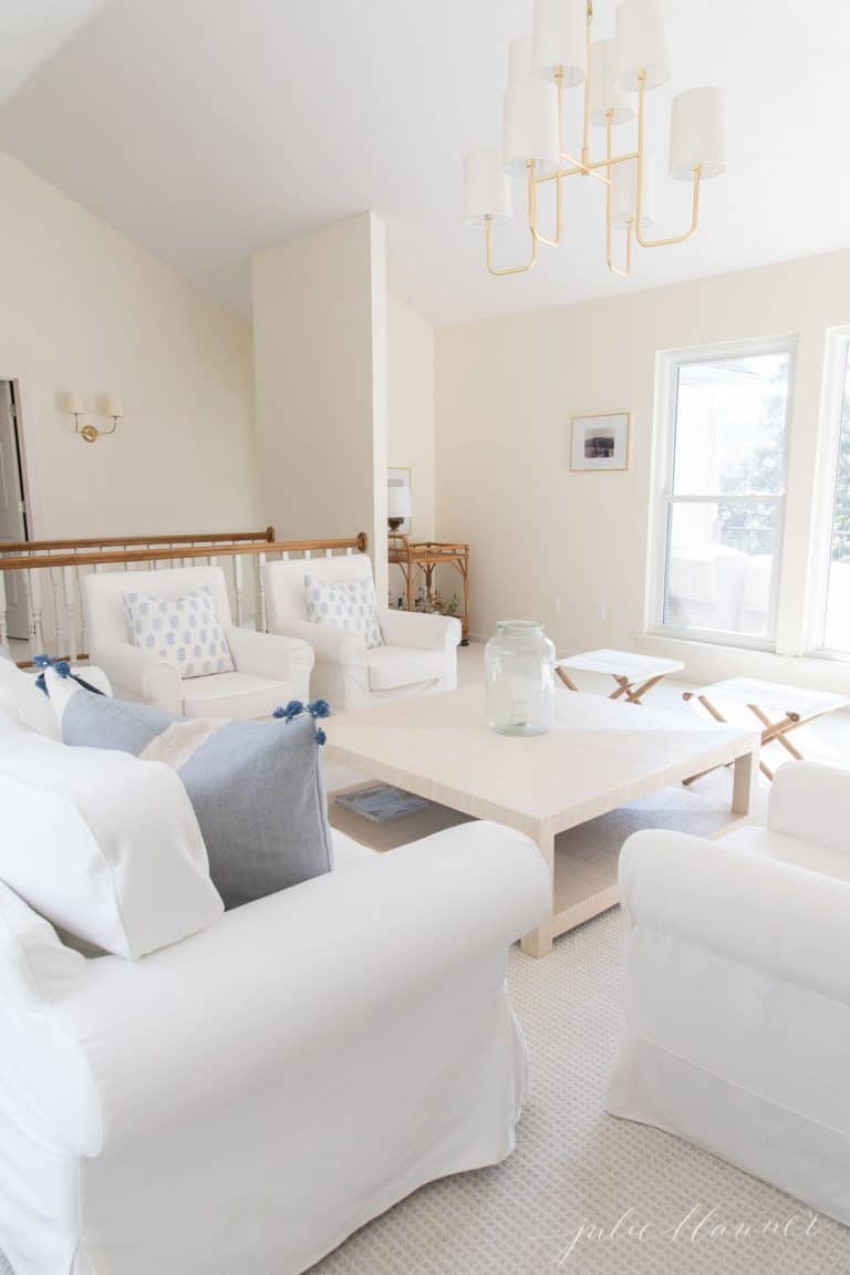 客厅里有白色家具，墙上涂着奶油蛋壳漆。
