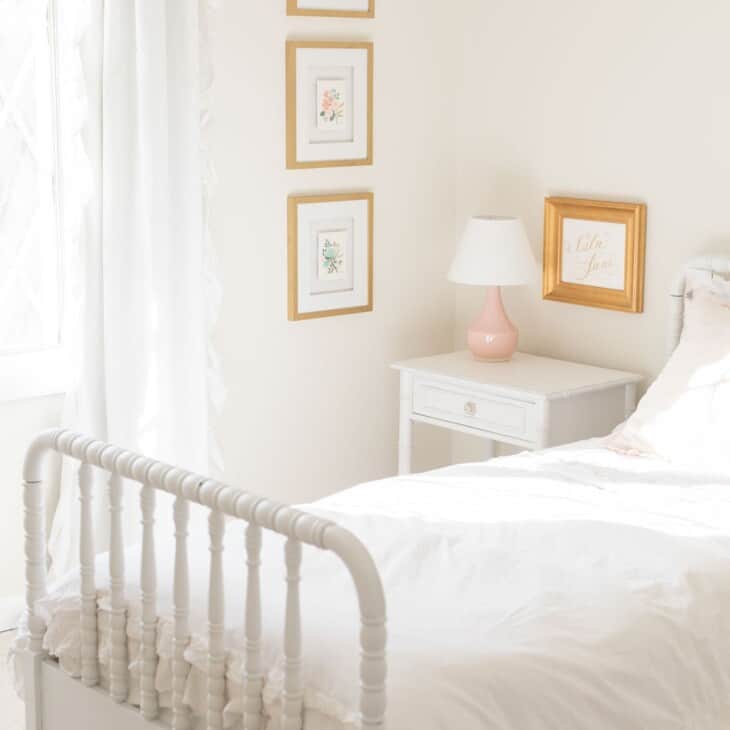 一间白色卧室的客厅，带有白色家具，墙壁上有奶油蛋壳油漆。