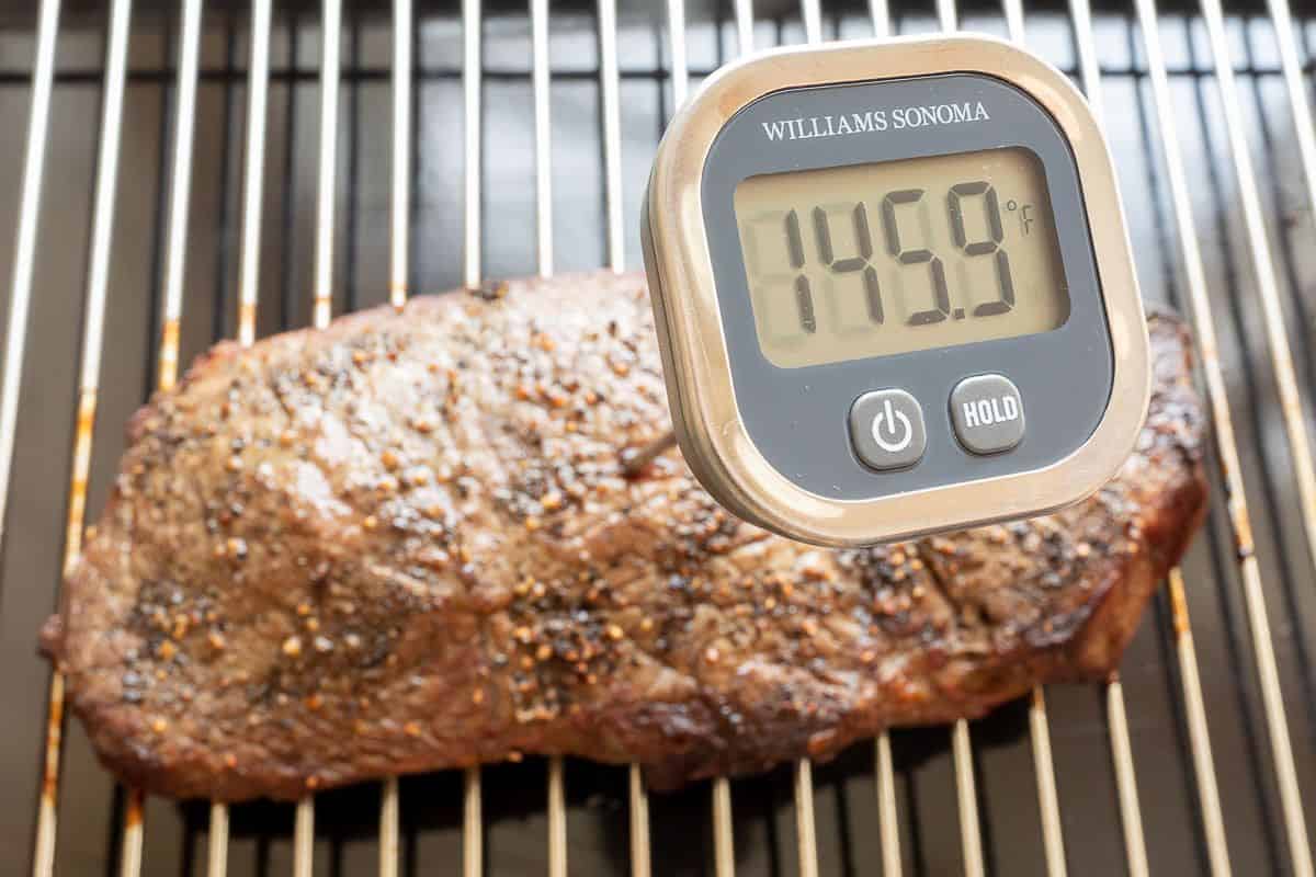烤牛排教程中，烤盘上的一块烤牛排，数字温度计显示145.9度。
