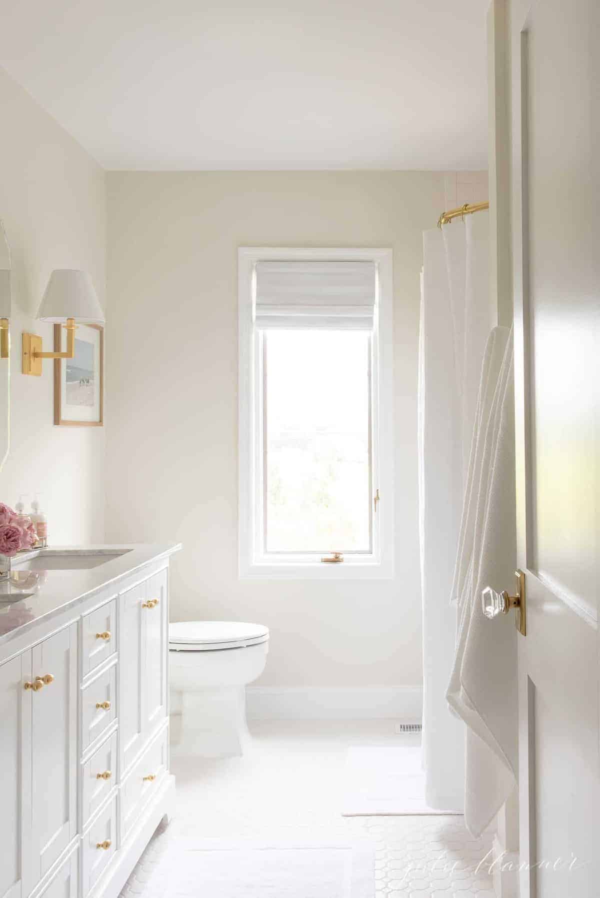 一间白色浴室，墙上有奶油油漆的缎面光泽。