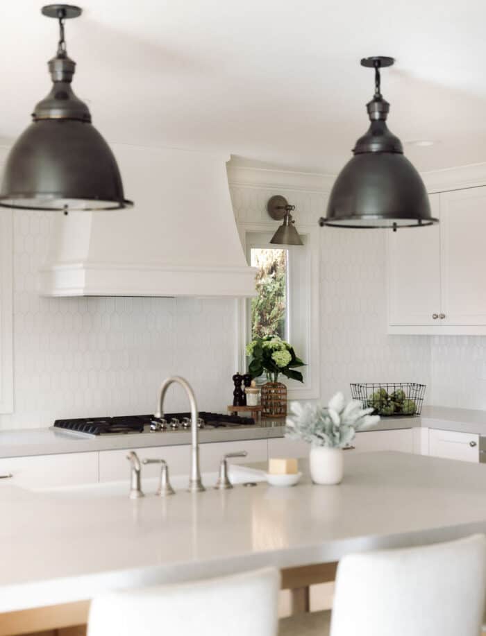 厨房有白色六角形瓷砖后挡板和白色橱柜。