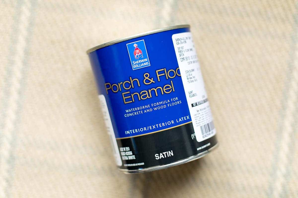 格子地毯上显示的乙烯基或油毡地板的油漆罐