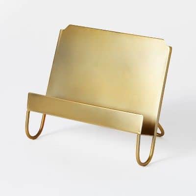 A gold cookbook stand on a white surface