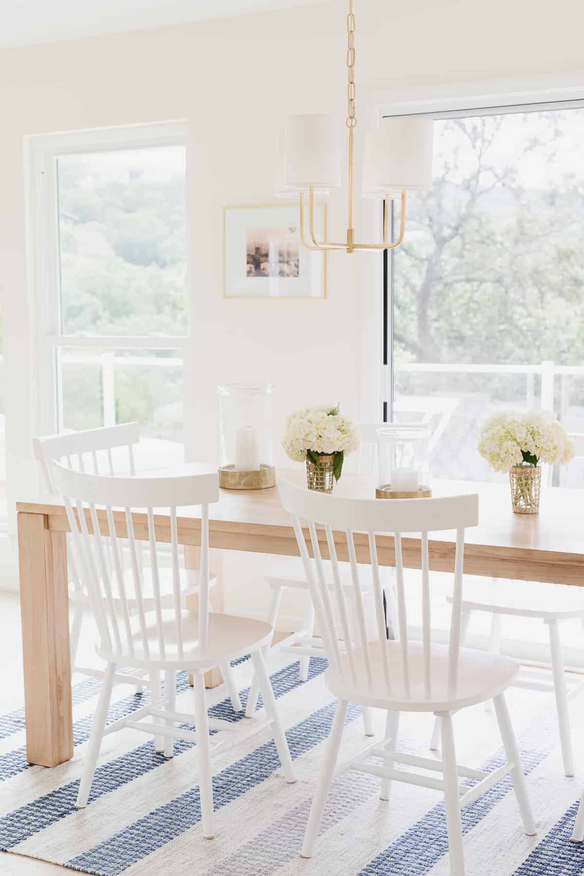 柚木餐桌，白色椅子和蓝色条纹地毯