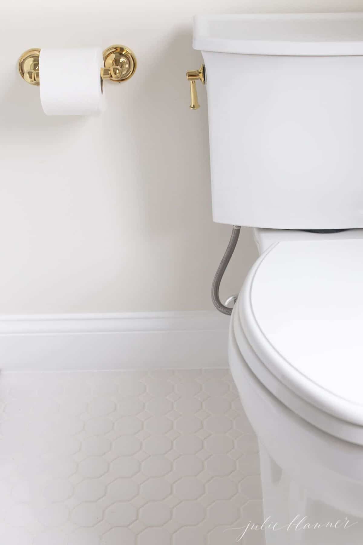 白色的地板、奶油色的墙壁和白色的装饰上的白色厕所的侧面特写。