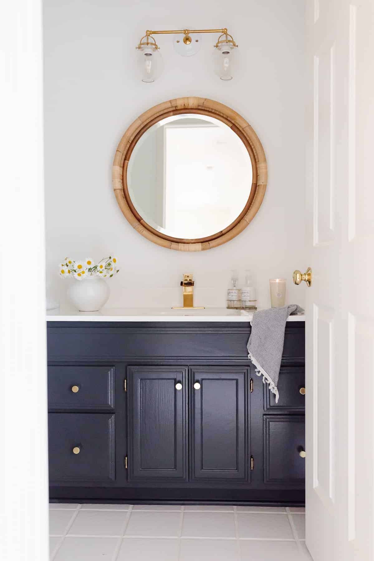 蓝白相间的浴室，配有藤镜和黄铜五金