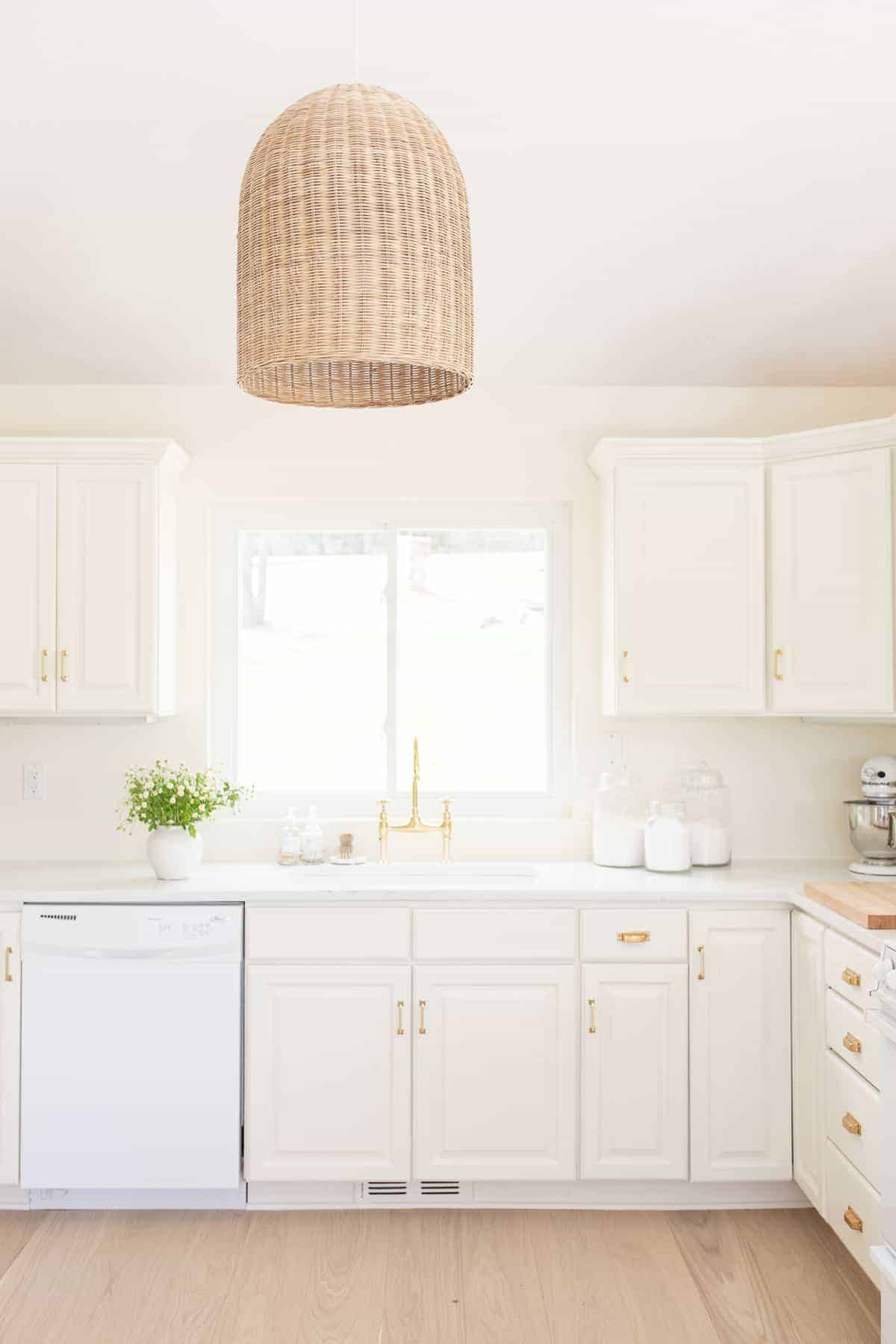 一间白色厨房，铺着宽木板白橡木地板。