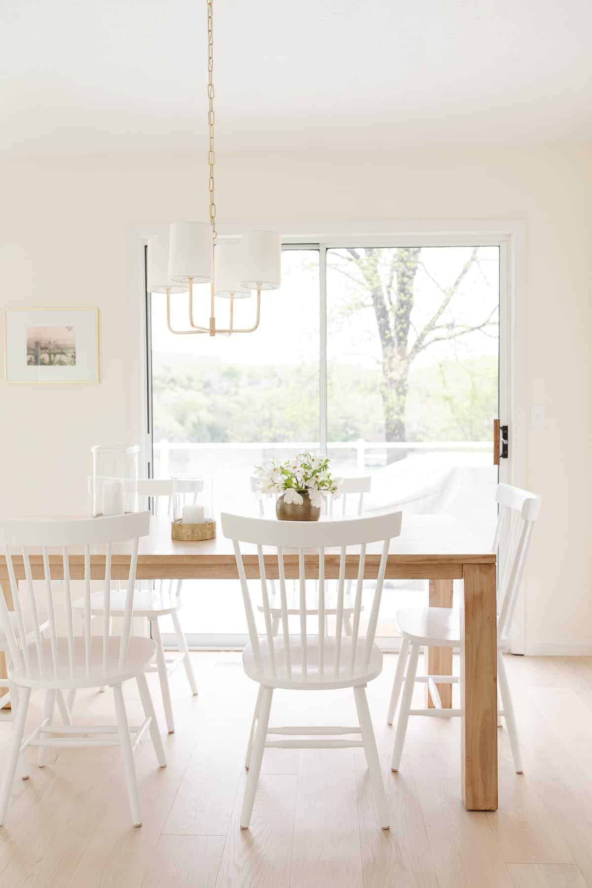 一个白色的厨房用餐区，宽阔的白色橡木工程地板。