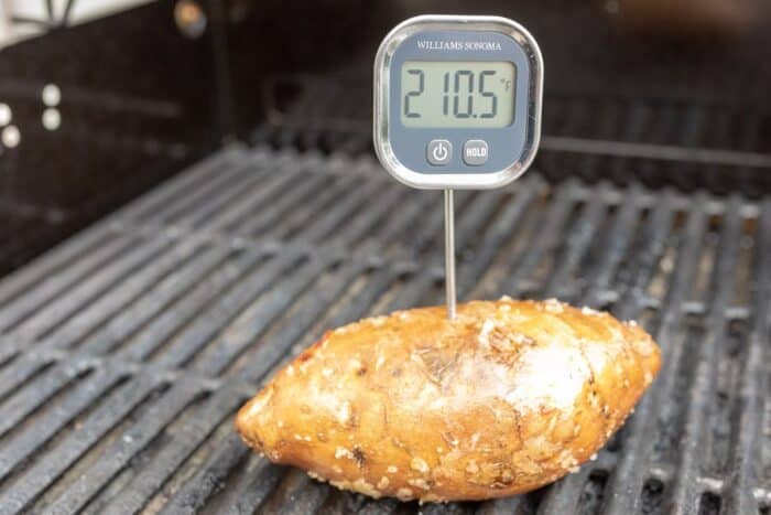 在烤架上的一个甜土豆与一个数字式温度计陷入其中。GydF4y2Ba