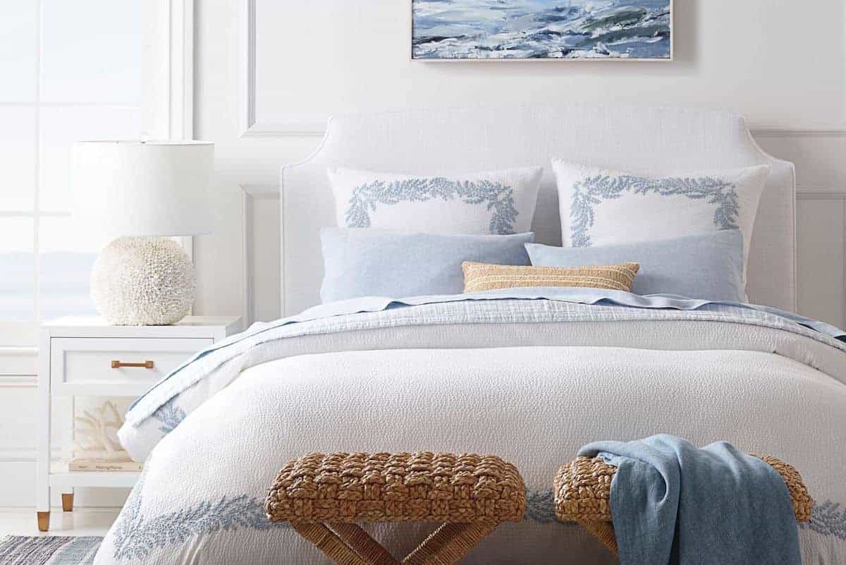一个白色的客房，床上有蓝色和白色的客座床上用品。