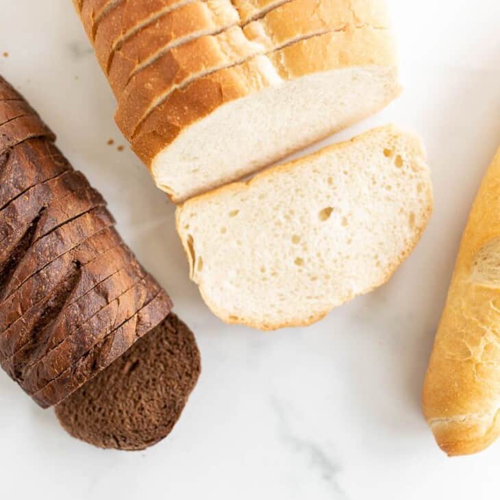三个不同的面包放在大理石表面上，在一个关于烤奶酪最好的面包的帖子里。gydF4y2Ba