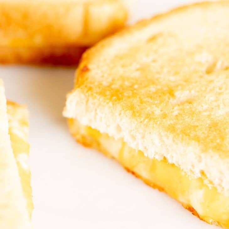烤箱烤奶酪三明治，切成薄片放在白色表面。
