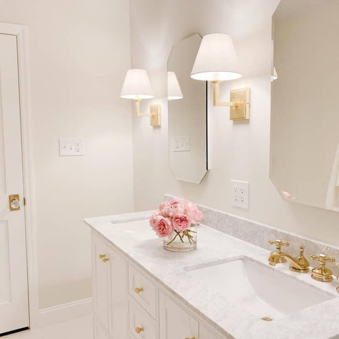 一间浴室，墙上的壁灯里有柔和的白色灯泡。