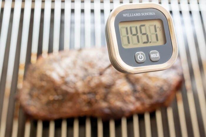 在烤架上的大型牛排，数字温度计内部读取145.1