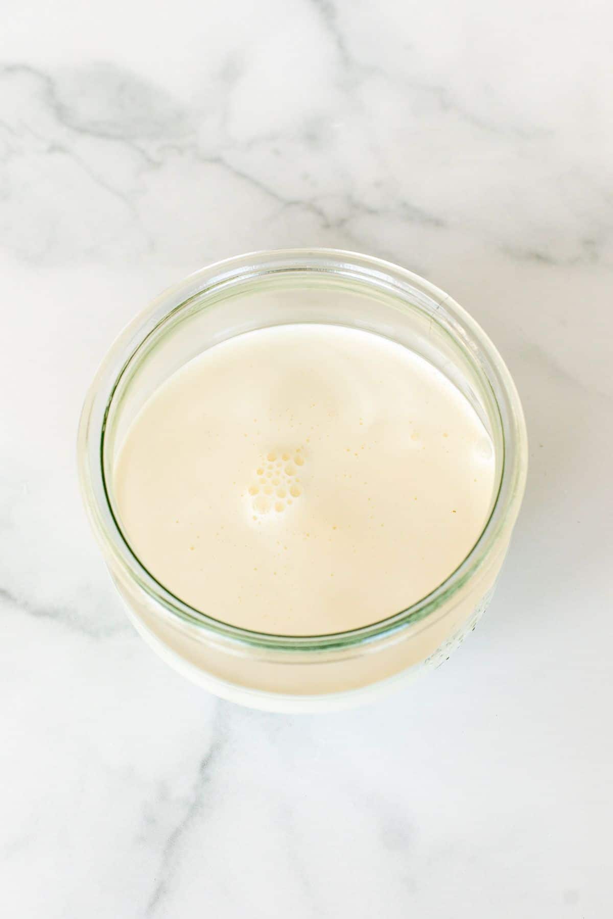 重鲜奶油作为鲜奶油的替代品，装在一个大理石表面的小透明玻璃罐里。gydF4y2Ba